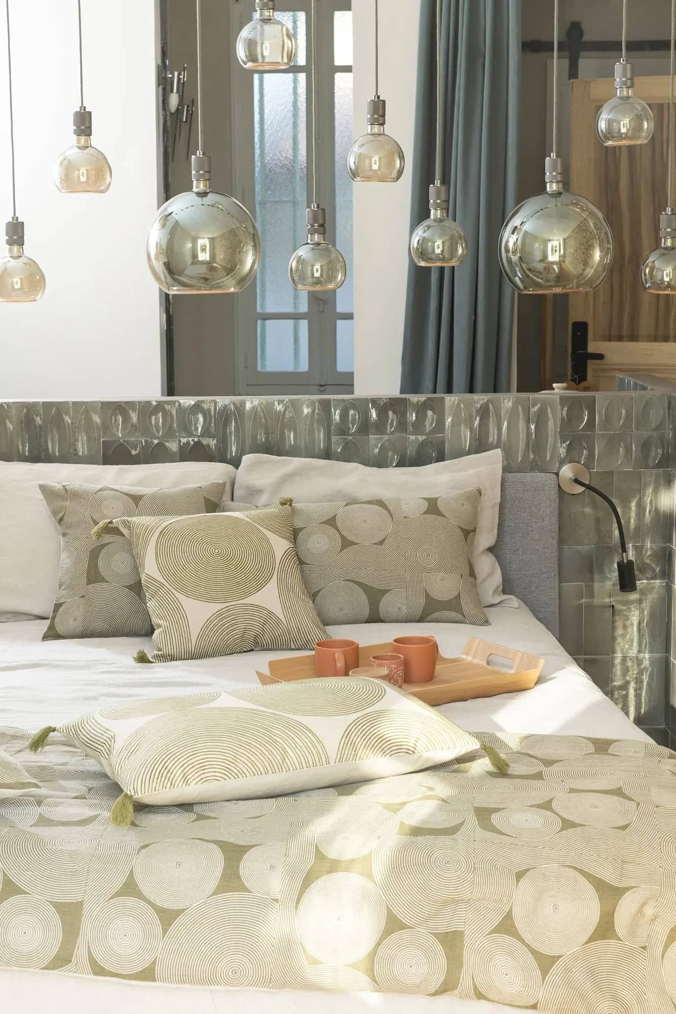 Chambre moderne avec lit habillé de linge de lit en lin aux motifs géométriques dans des tons beige