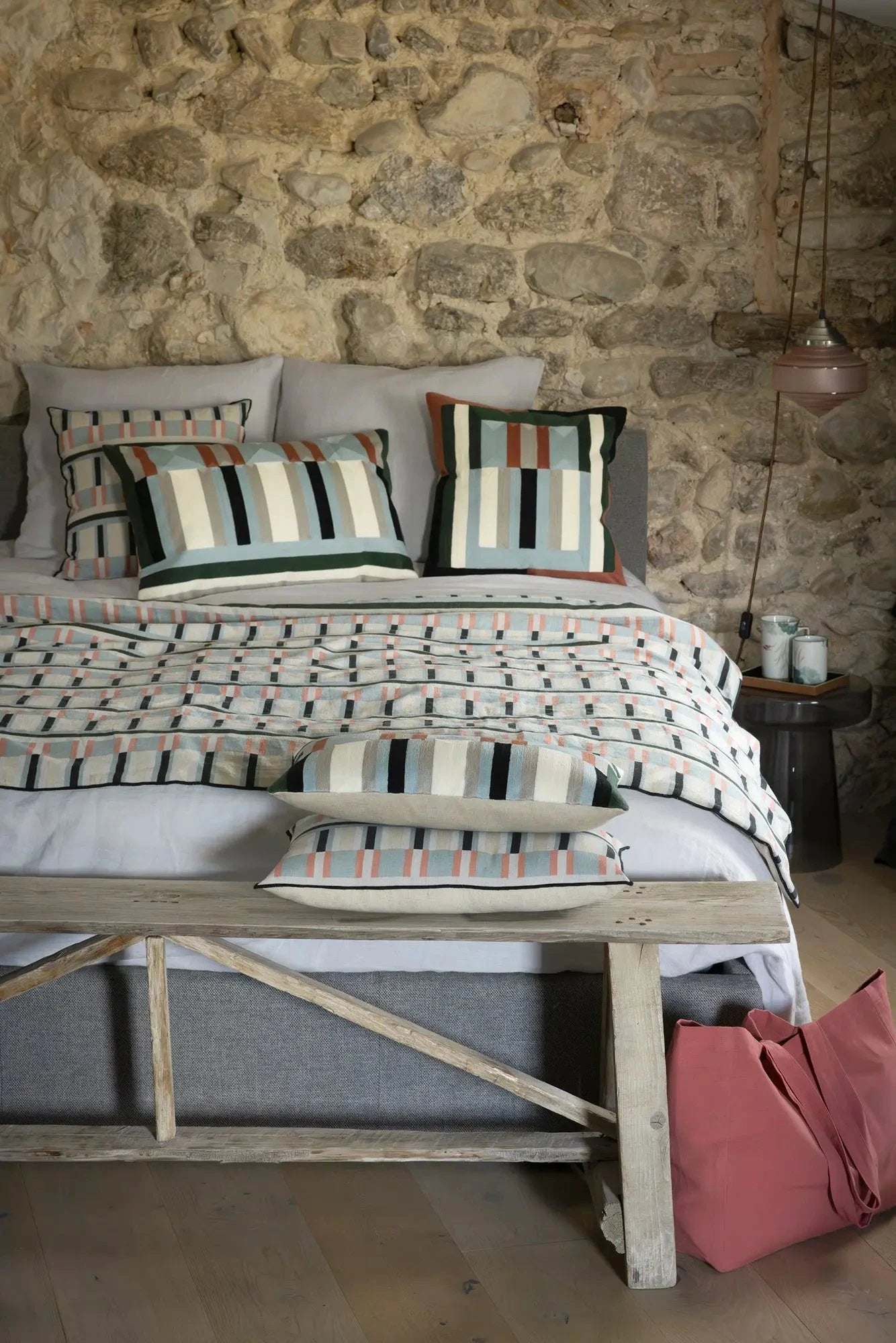 Chambre décorée avec linge de lit en chanvre aux tons naturels et coussins à motifs floraux
